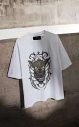 Remera blanca de corte holgado con estampa frontal de un perro chihuahua con diseño gótico, rodeado de elementos ornamentales y una calavera.