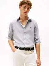 Camisa de manga larga Tommy Hilfiger de corte slim, confeccionada en tejido de piqué Oxford color azul claro. Presenta cuello inglés, cierre frontal con botones y el logo de la marca bordado en el pecho.