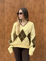 Sweater tejido con escote en V y calce relajado, con diseño de rombos en colores bordó y celeste.