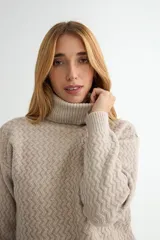 Polera de tejido de punto con cuello alto y textura acanalada en zigzag. Presenta mangas largas y puños ajustados, con un diseño clásico y versátil.