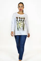 Remera de manga larga color blanco con cuello redondo y estampa frontal de figuras femeninas estilizadas en tonos dorados y marrones.