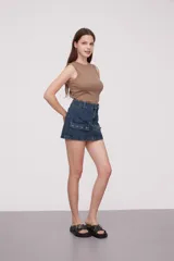 Falda corta de jean color beige claro, de corte al cuerpo, con tiro bajo y bolsillos cargo grandes y planos en los laterales.