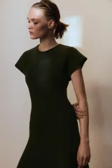 Vestido largo de punto en color verde oscuro jaspeado, con cuello redondo, manga corta y falda con corte evasé.