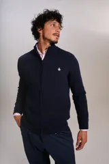 Cardigan de punto color azul marino, con cuello alto, cierre frontal completo y puños acanalados. Presenta el logo de la marca bordado en el pecho.