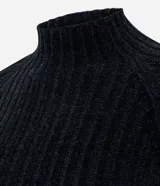 Blusa cropped de punto chenille color negro, con cuello alto y mangas largas raglán. Presenta una textura acanalada y pequeños puntos brillantes aplicados en el frente.