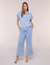 Pantalón crop de textura tramada tipo denim lavado, de calce limpio y caída fluida, con cintura elástica, bolsillos laterales y silueta ancha y recta.