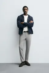Pantalón de corte slim fit confeccionado en tejido elástico, con cintura elástica, cierre frontal con cremallera y botón, bolsillos laterales y bolsillos traseros de vivo.