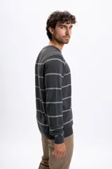 Buzo de punto con diseño de franjas horizontales finas en color gris oscuro, cuello redondo y puños acanalados.