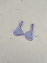 Top de bikini modelo triángulo en color lila, con textura acanalada y breteles regulables. Cuenta con forro interno y cierre mediante atadura en la espalda.