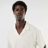Remera de punto color blanco, de manga corta, con cuello solapa y diseño holgado.
