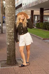 Sandalia de cuero negra con plantilla marrón y base de corcho. Presenta una tira ancha sobre el empeine con hebilla metálica plateada.