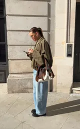 Chaqueta tipo bomber de gamuza en color verde oliva, con cuello camisero, cierre frontal oculto y diseño de corte holgado con hombros caídos.