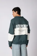 Buzo tipo polo de calce relajado con diseño de bloques de color en tonos marrón y blanco. Presenta cuello polo, cierre frontal parcial y logo estampado en el pecho. Confeccionado en tejido pesado con estructura.