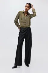 Camisa verde militar con estampado geométrico de líneas blancas, cuello clásico, botones frontales y mangas largas con puños abotonados.