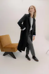 Tapado largo de jean negro, con cuello solapa y cierre frontal. Presenta puños con detalle de cinta de terciopelo y un pin bordado con logo en la espalda.