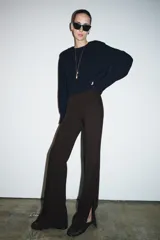 Pantalón de tiro alto con raya planchada en el delantero, corte flare con aberturas en el bajo y cierre lateral con cremallera oculta.