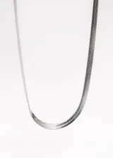 Cadena dorada de acero quirúrgico con eslabones planos tipo serpiente, cierre de mosquetón y cadena de extensión.