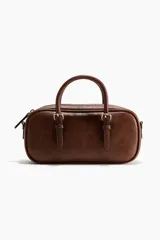 Morral rectangular de cuero sintético marrón, con cierre superior, asas cortas y correas con detalles de hebillas metálicas.