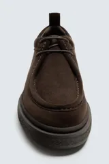 Zapato de cordones con diseño tipo mocasín, confeccionado en piel con acabado de serraje en color marrón. Presenta detalle de costura en el empeine y suela de goma texturizada a tono.