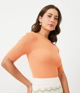 Blusa celeste de punto acanalado con cuello barco y mangas cortas.