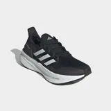 Championes de running Adidas Ultraboost 5 en color negro con las tres tiras características en blanco. Presentan una entresuela con tecnología Light BOOST para una amortiguación ligera y retorno de energía, sistema Torsion para mayor estabilidad y suela de caucho Continental para un agarre óptimo. El exterior está confeccionado en tejido textil transpirable.