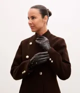 Guantes de cuero sintético color negro con detalle de tachuelas metálicas doradas distribuidas en el dorso. Cuentan con forro interior para mayor calidez.