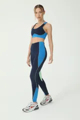 Calza deportiva tiro alto azul con recortes en azulino y verde, y logo BASSET 00's en la cintura.