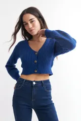 Cárdigan color borgoña de tejido de punto con textura acanalada, escote en V, cierre frontal con botones y mangas largas abullonadas.