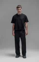 Pantalón cargo de corte oversize confeccionado en microfibra técnica con sutil elasticidad. Presenta cintura elástica, bolsillos laterales y un bolsillo cargo con cierre de broche snap. Incluye un sistema de elásticos con tancas en los tobillos para regular la apertura y la silueta.
