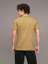 Remera color ocre de algodón con cuello redondo y mangas cortas. Cinta con logo en espiguilla de Calvin Klein en los laterales.