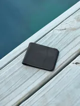 Billetera de cuero color negro, con múltiples ranuras para tarjetas y compartimento para billetes.