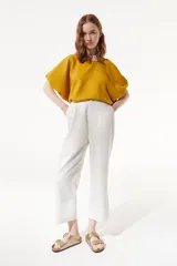 Top corto amarillo de calce oversize con cuello redondo y mangas abullonadas.