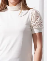 Blusa color blanco de crepe, marca Cable & Gauge. Cuello halter con detalles plisados y mangas cortas de encaje con destellos brillantes.