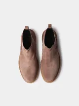 Botin de mujer de cuero negro, estilo chelsea, con elásticos laterales, tirador trasero y suela dentada de goma color caramelo.