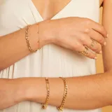 Pulsera de cadena fina en oro 18k con dijes de circonias engarzadas distribuidos a lo largo de la misma.