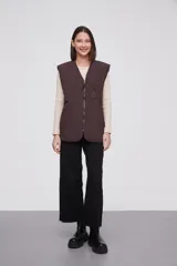 Chaleco marrón con cierre frontal y bolsillos con cierre.