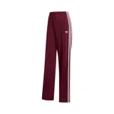 Pantalon deportivo Adidas modelo Firebird, color bordó, con diseño de pierna recta, cintura elástica, bolsillos laterales con cierre y las icónicas tres tiras blancas en los laterales.