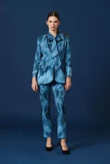 Saco de mujer color azul con estampado de plumas, solapa clásica, bolsillos con solapa en el frente y cierre frontal de un botón.