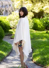 Ruana de textura liviana en color crudo, con diseño amplio y bordes decorados con volados románticos.