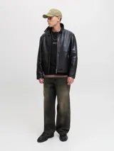 Buzo negro de manga larga con cuello redondo y calce relajado. Presenta un pequeño bordado en el pecho con el texto "Originals Studio" en cursiva blanca.