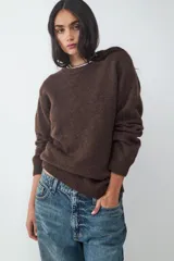 Sweater de manga larga confeccionado en tejido de punto suave. Presenta un diseño clásico con cuello redondo y terminaciones acanaladas en puños y bajo.