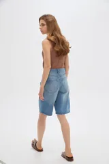 Bermuda de jean azul de tiro alto, corte boyfriend con bolsillos y terminaciones deshilachadas.
