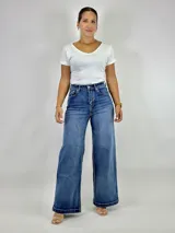Pantalón de jean azul de tiro alto, corte wide leg y ruedo desflecado.