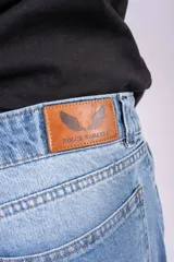 Pantalón de jean tiro bajo con corte wide leg y lavado celeste vintage. Presenta un diseño de pernera ancha y recta, con cierre de botón y cremallera, y bolsillos laterales y traseros.