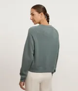 Buzo de corte regular confeccionado en modal, con cuello redondo, mangas largas y costuras decorativas visibles. Presenta un diseño minimalista y versátil.
