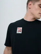 Remera de manga corta color beige, con cuello redondo y diseño holgado. Cuenta con un pequeño estampado rectangular en el pecho con motivo futbolero.