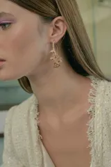 Chaqueta de tweed color crema con flecos en cuello, puños y ruedo. Tiene doble botonadura dorada y bolsillos frontales de parche.