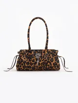 Cartera de hombro de cuero vacuno con pelo y estampado animal print de leopardo. Cuenta con herraje metálico tipo lock con llave colgante, asas largas y tiras laterales ajustables.