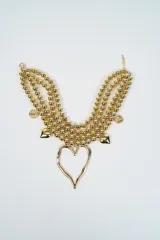 Collar de tres hileras compuesto por esferas doradas, con dijes colgantes en forma de monedas y corazones pequeños, finalizando en un dije central grande con forma de corazón irregular.