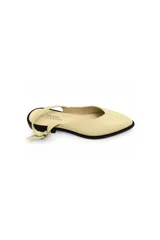 Zueco destalonado color beige con punta en V, tira trasera regulable con hebilla y suela baja negra en contraste.
